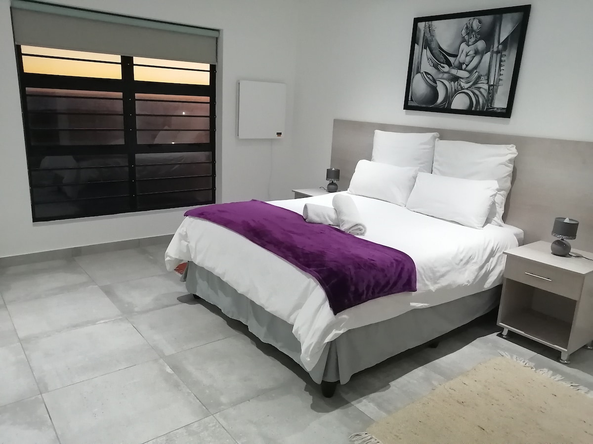 Slaapkamer 2 met ensuite badkamer - enkele wastafel. Prachtig uitzicht op zee.