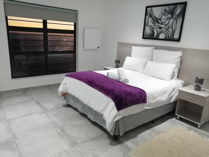 Slaapkamer 2 met ensuite badkamer - enkele wastafel. Prachtig uitzicht op zee.