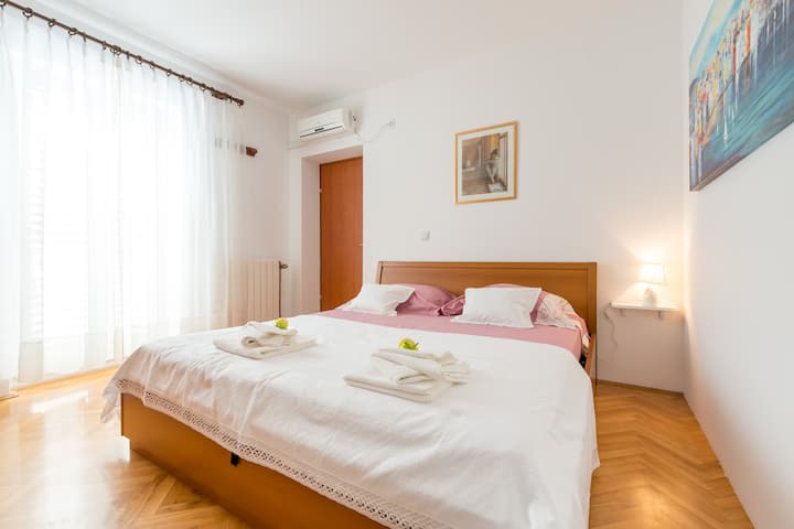 ห้องนอนมีเตียงคู่ขนาดใหญ่และเครื่องปรับอากาศ