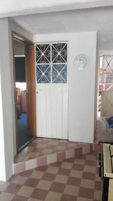 A la izquierda , dormitorio, de frente puerta baño, a la derecha salida al jardín.