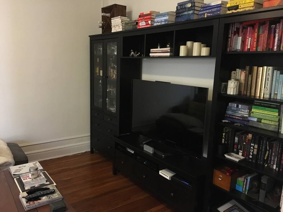 Living room has a smart TV with cable and plenty of entertainment devices.
