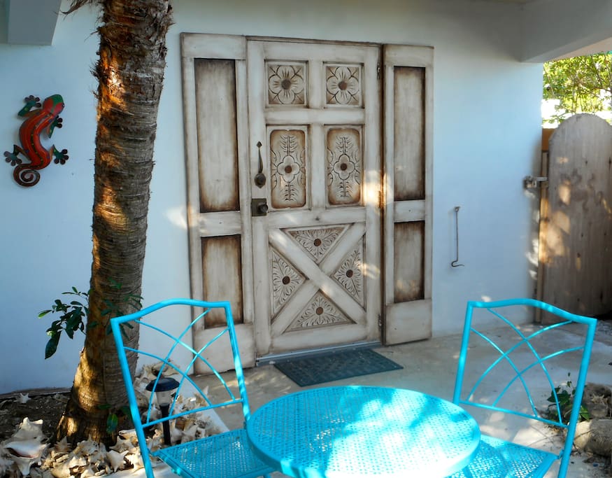 The entrance to the unit is an antique hand carved wood door and there's a bistro table to relax over a cup of coffee or a glass of wine.