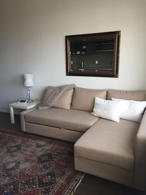 The bottom section of the couch pulls out to become a cozy bed, with an extra duvet, soft sheets, and great pillows.