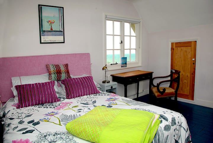 Romantic bedroom with dual aspect. Enjoy views up the wild-flower meadow and over the sea!