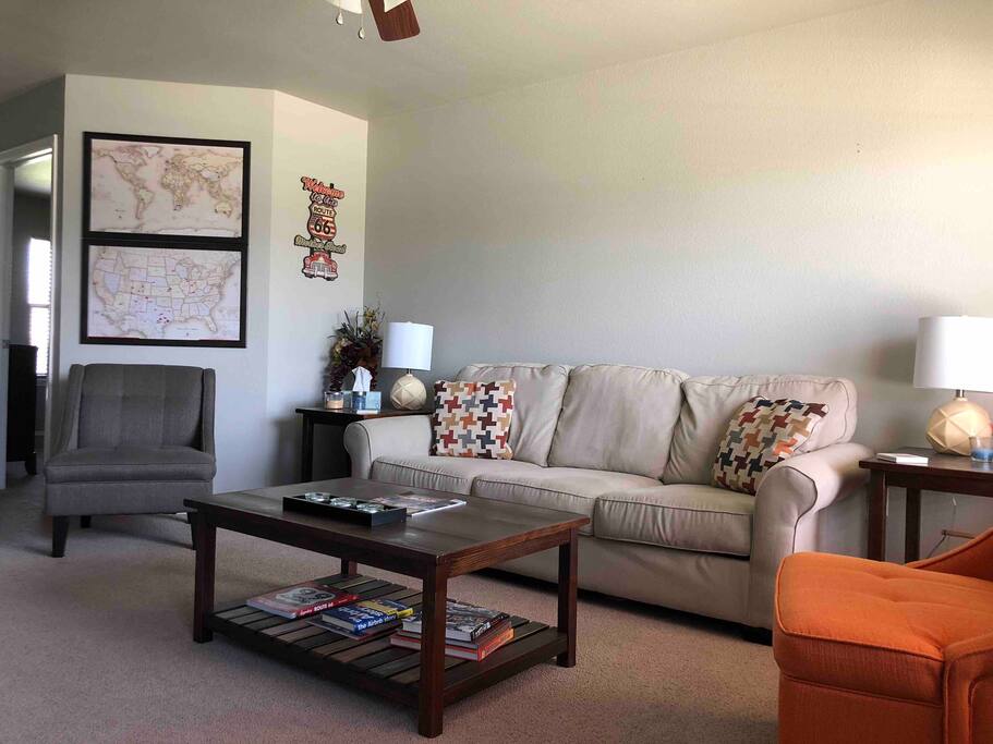 Living Area with couch, tables, two chairs and a 50" TV with premium channels.