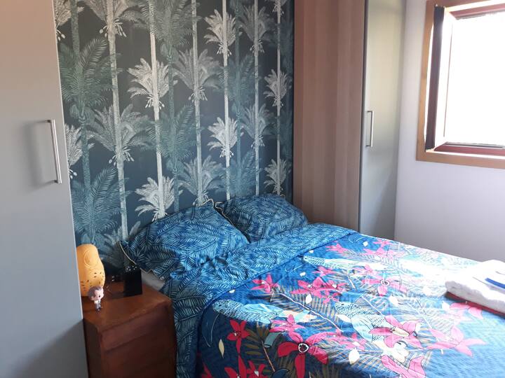 ห้องนอน 1 พร้อมวอลล์เปเปอร์ป่าสวยๆและน้ำสลัดขนาดใหญ่ 2 ชิ้นที่ด้านใดด้านหนึ่งของเตียง