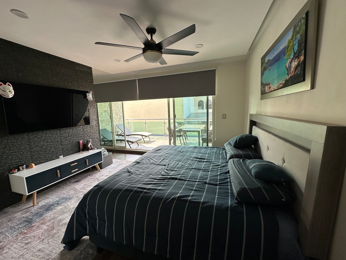 Glavna spavaća soba s bračnim krevetom, TV s uslugama streaminga i pogledom na prostranu terasu 