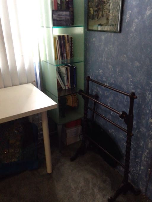 Table with natural lighting and several shelves for books/other items.