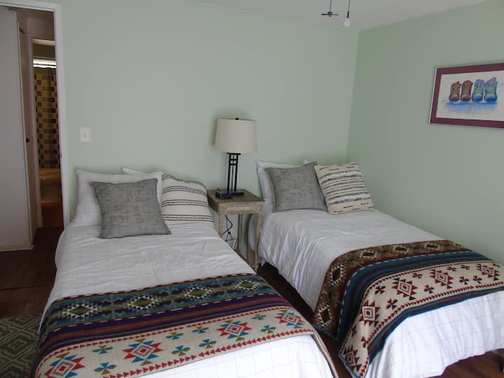 Dormitorio con camas individuales. Baño completo adyacente a la habitación.