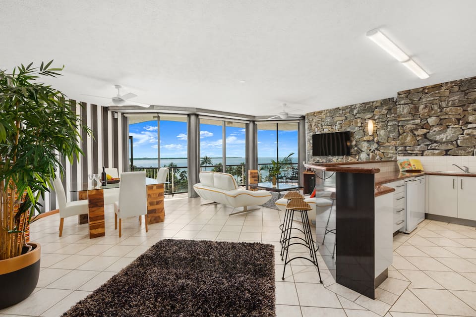 Living room with beachside views through the window of Coral Sea Penthouse, Cairns City