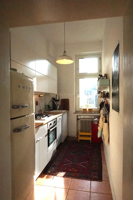 Küche mit Backofen, Gasherd, Spülmaschine und großem Kühlschrank