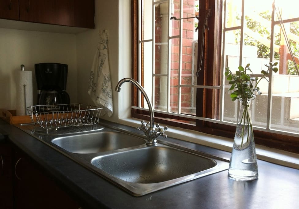 Fully equipped kitchen with windows onto courtyard.