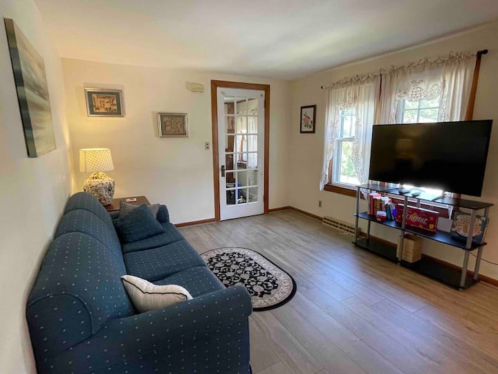 Salon avec télévision connectée de 50 pouces, jeux de société et livres.