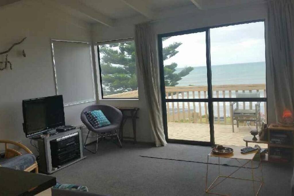 Apartment lounge area with view out to deck and ocean