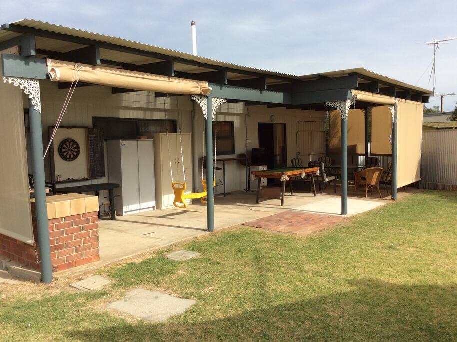 Large outdoor living area with a pool table and out door setting. Our side tv .