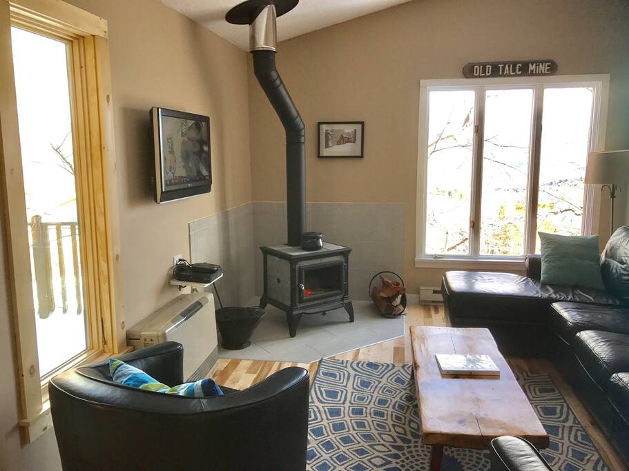 Bright living-room with cozy wood stove, leather chairs and couch. Also a new flatscreen tv.