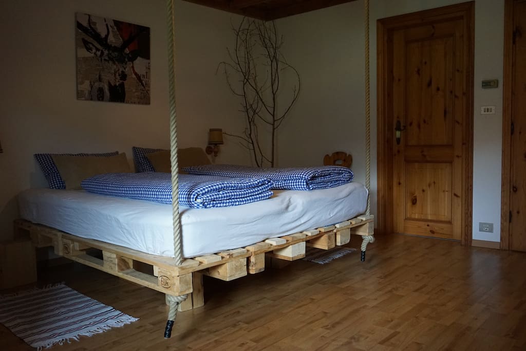 Double bed with a sheep wool mattress hanging from the ceiling for an extra good sleep