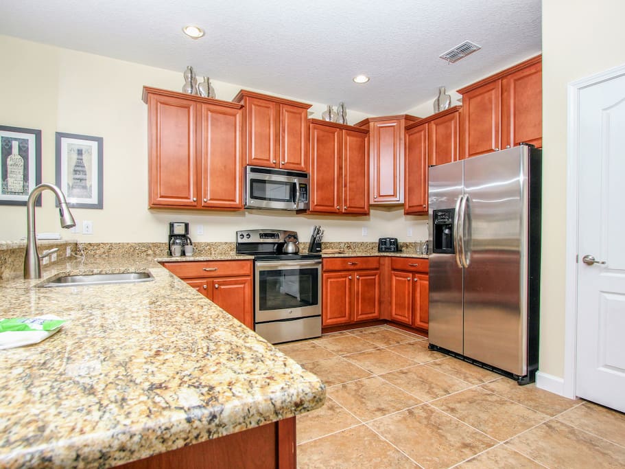 Open concept kitchen with granite countertops & stainless steel appliances