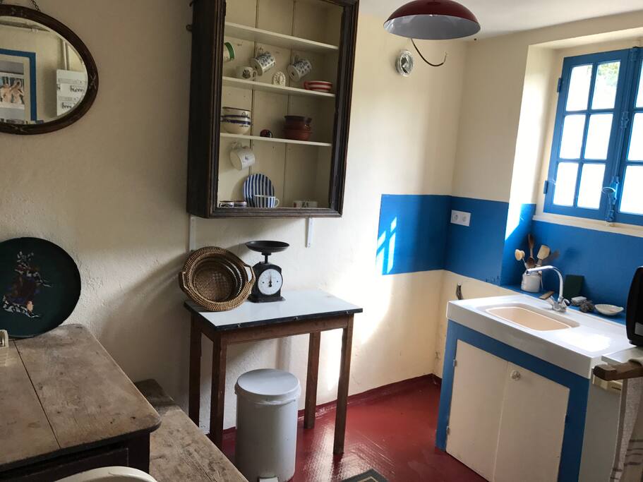 Small simple kitchen with cooker, fridge and small breakfast table.