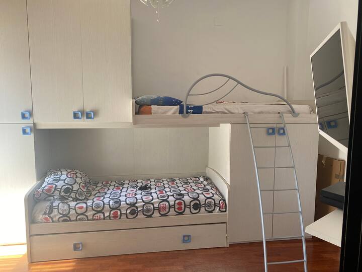 Spavaća soba s tri kreveta i TV-om 