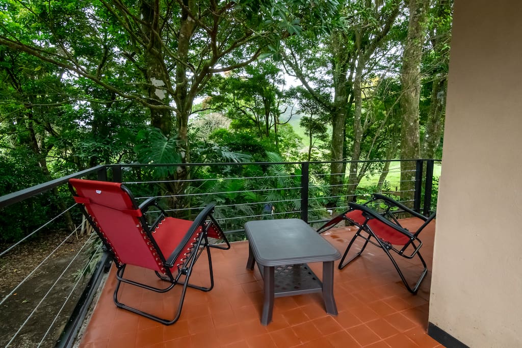 Balcón con sillas reclinábles con vista al bosque y al atardecer / Balcony with reclining chairs with views of the surrounding forest and to the sunset.
