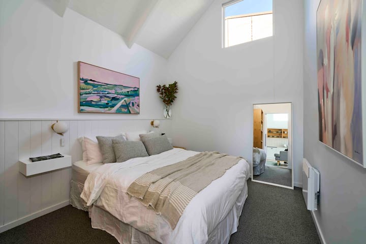 Bedroom 2 with queen bed, full length mirror, electric heater and wardrobe.