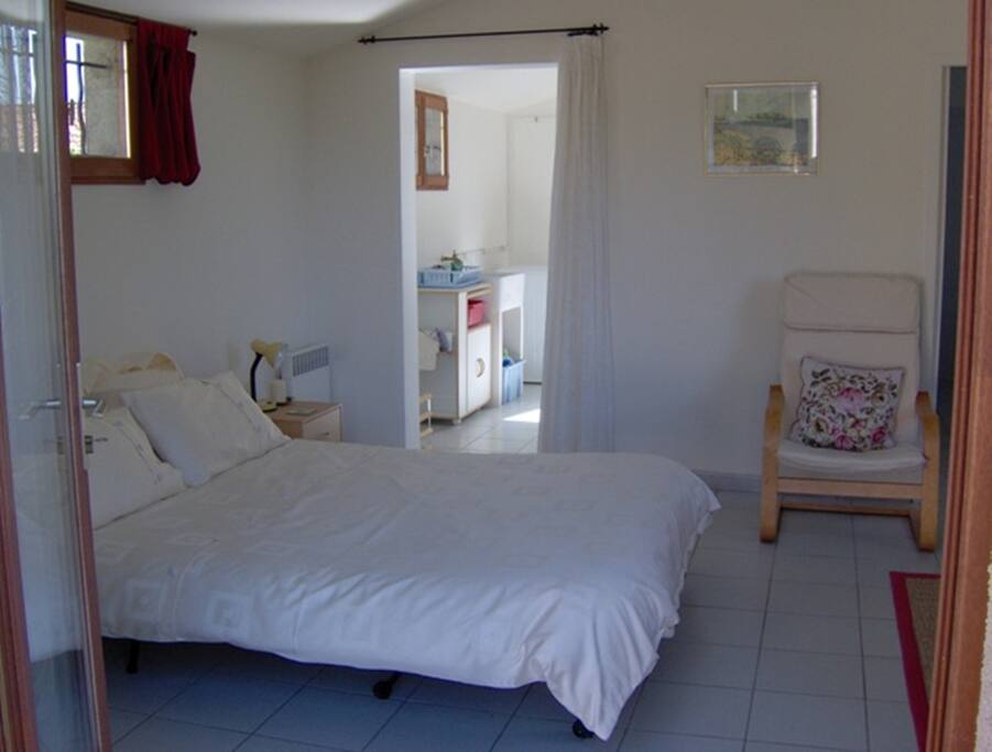 View from tiled patio area into studio & kitchen beyond