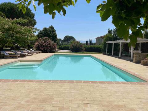 villa with a pool surrounded by greenery