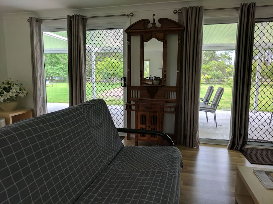 Double sliding doors open out to a large veranda with outdoor seating area and BBQ area.