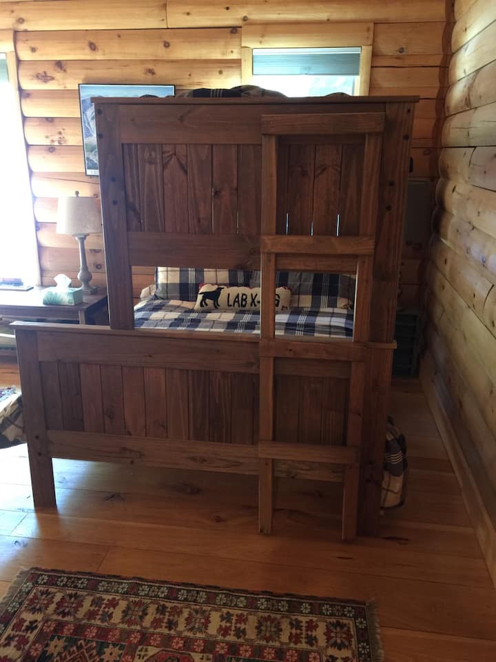 Bedrom #2 - Poschodová posteľ s manželskou posteľou. Ďalšia samostatná posteľ je na ľavej strane izby.