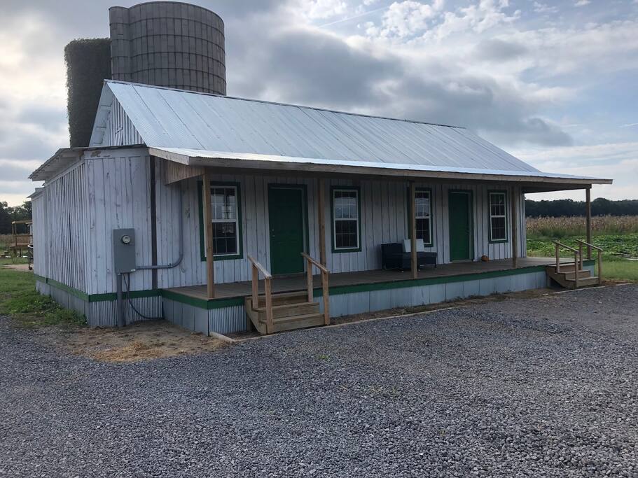 View of the front of the house. It is made from two shipping containers, insulated, then covered with reclaimed wood to look like an old farm house. It looks even more natural in person.