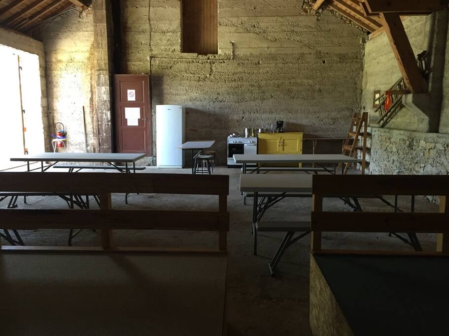 Grand espace avec tables et bancs à l'intérieur, pour prendre les repas ou pour les activités d'intérieur