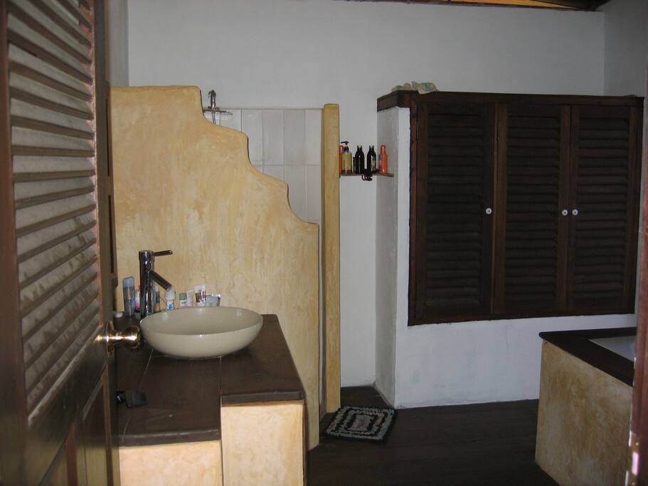 bathroom with shower and bathtub. door to outside shower and garden.