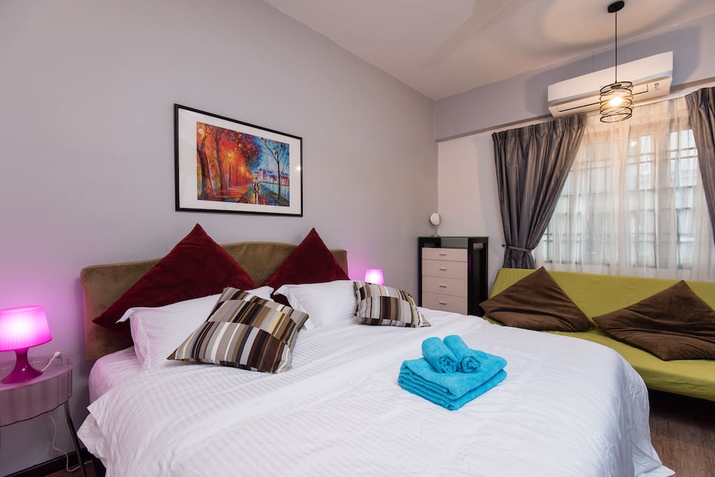 Master bedroom furnished with a king size bed, sofa bed, wardrobe and chest of drawers