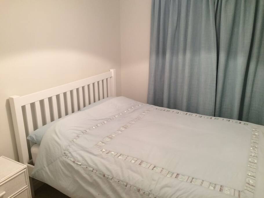 2nd bedroom with king size bed and bedside table.