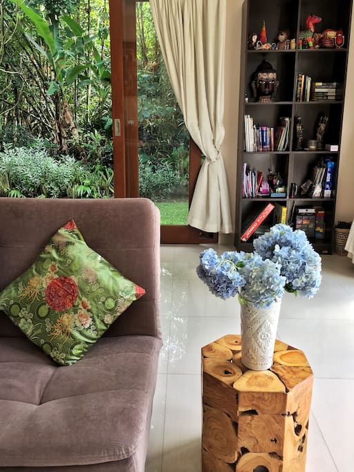 Gorgeous sun-filled living room with floor-to-ceiling windows and access to the tropical garden.