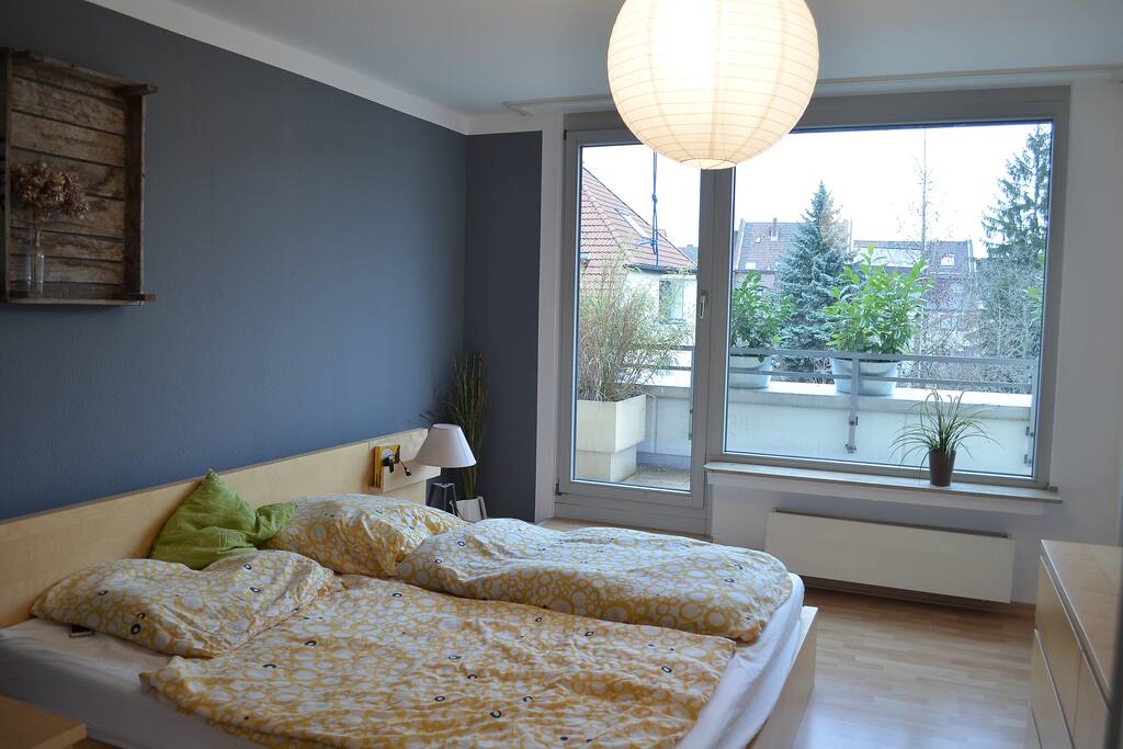 Gemütliches Schlafzimmer mit Zugang zum Balkon und eigenem Badezimmer.