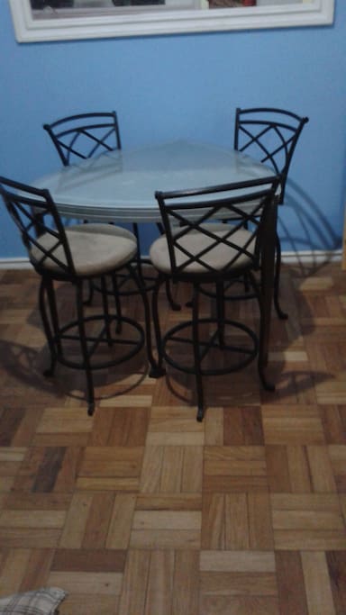 Mesa em vidro co pes em ferro e cadeiras giratorias