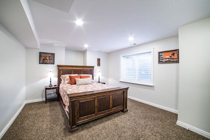 غرفة نوم كبيرة بسرير بحجم كوين ومصابيح تعمل باللمس بجانب السرير وشواحن مقابس سرير (على جانبي السرير) لأجهزة الكمبيوتر والأجهزة اللوحية والهواتف