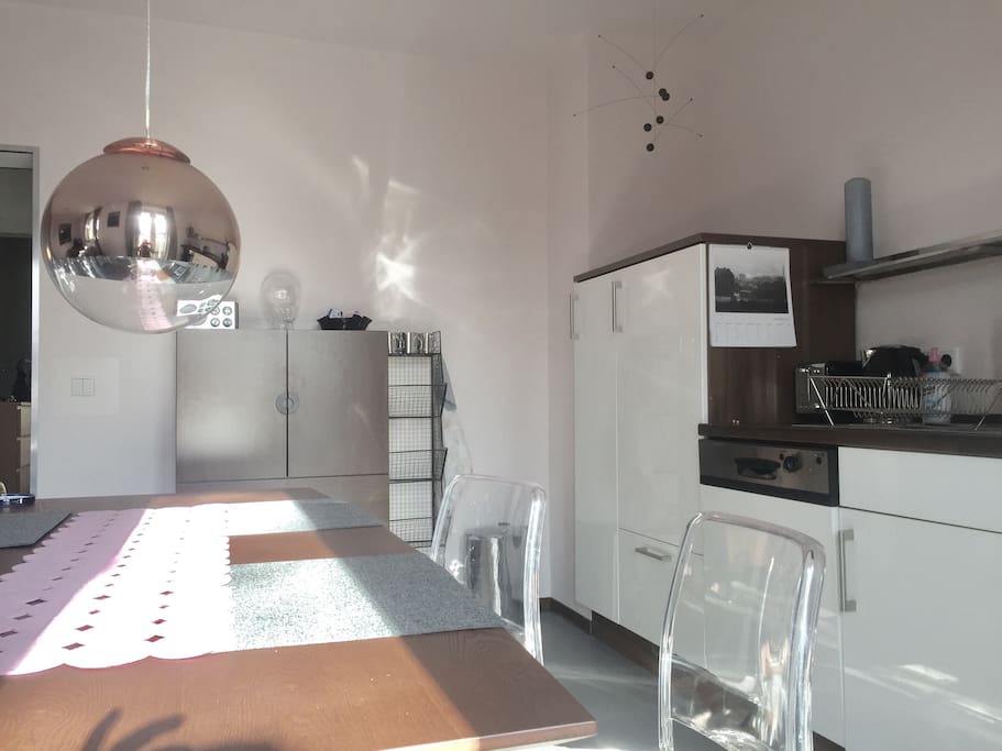 Esstisch mit Platz für 4 Personen, skandinavisches Mobile über dem Kühlschrank.