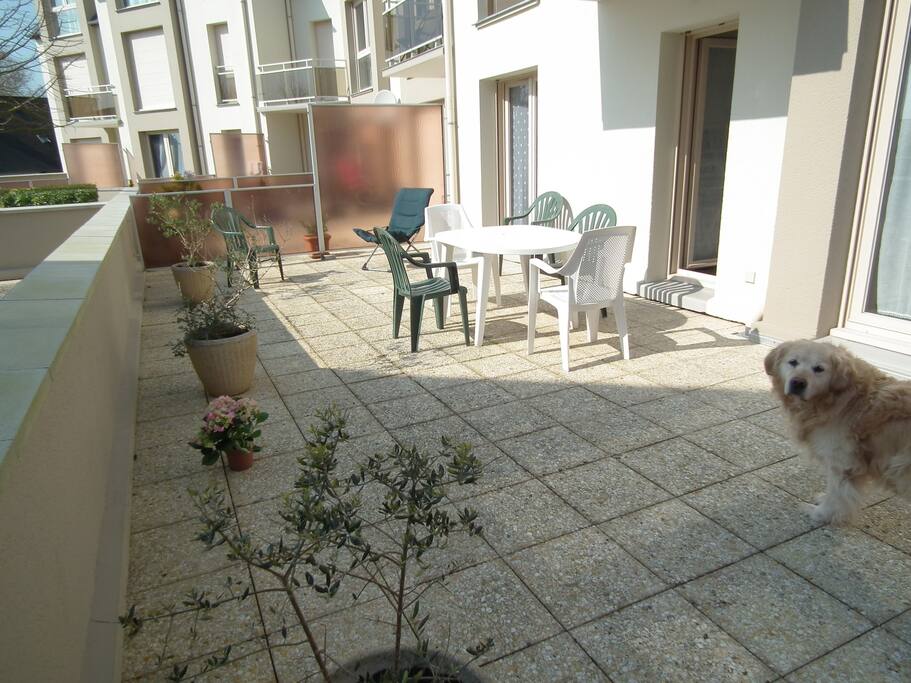 terrasse privative orientée sud avec mobilier de plein air et parasol