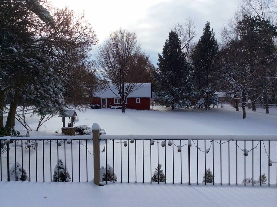 View of the barn in the winter with a beautiful yard and setting.