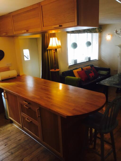 The kitchen area, with large oak dining bar. Looking towards the sitting area and open fire