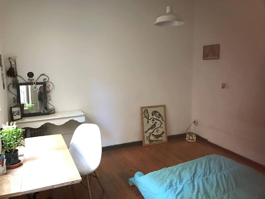 Habitación iluminada, techos altos, piso de madera.