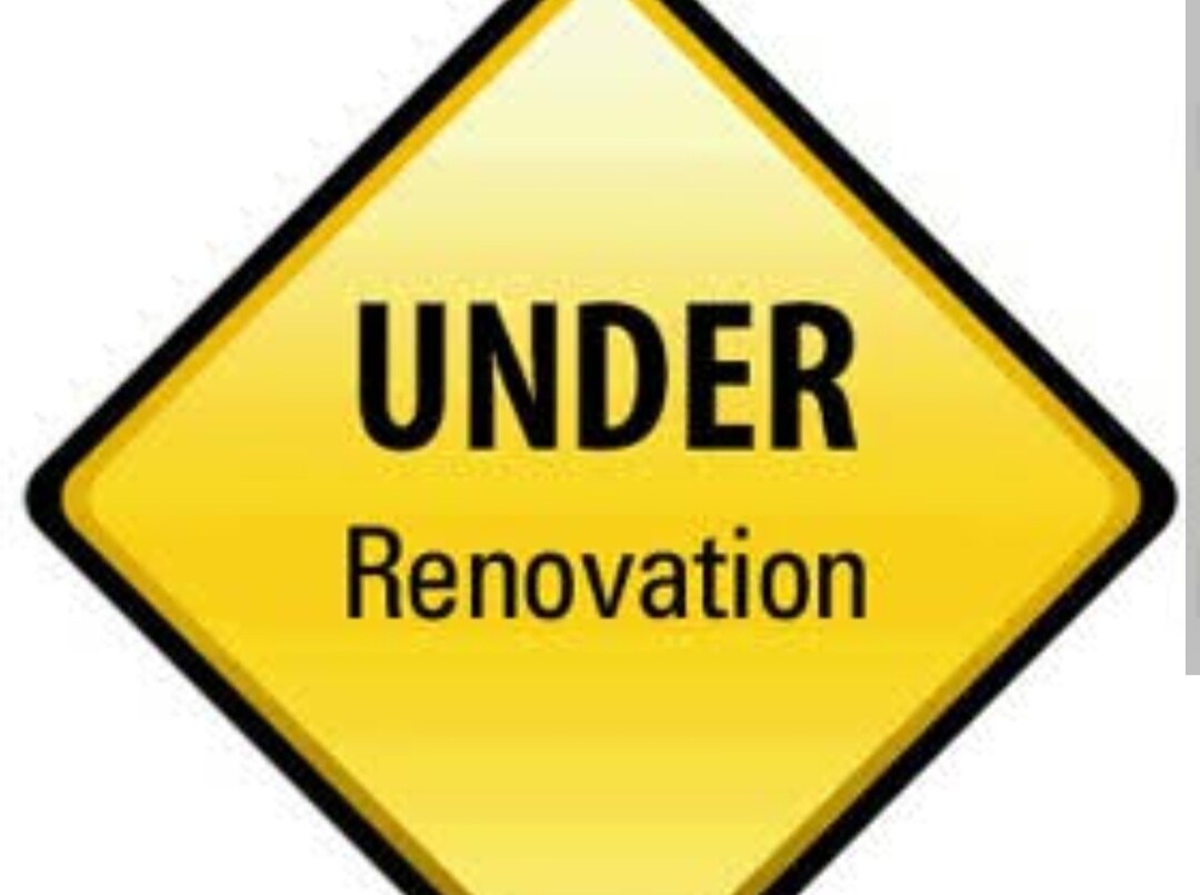 A bright yellow diamond-shaped sign displays the words 'UNDER Renovation' in bold black letters. The sign indicates ongoing construction or improvements, emphasizing the space's transitional state.
