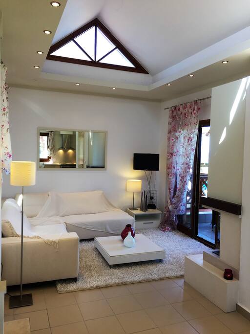 the living room with flat screen TV and interior fireplace