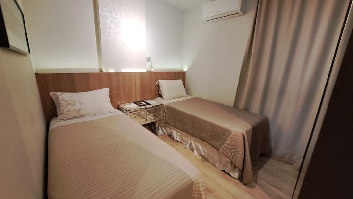 مسكن مع سريرين مفردين وخزانة ملابس مقسمة وفردية.