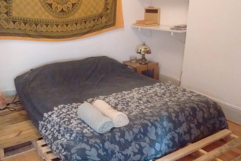 The bedroom has a queen-sized bed tucked away in a cozy nook.