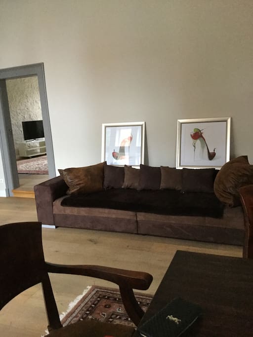 Empfangszimmer mit großer Couch , TV und Esstisch für 6 Personen
