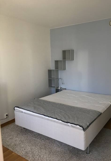The bedroom features a double bed and a view of the atrium.